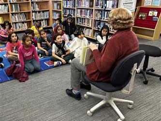 Ms. Shari reading a book to students during library time